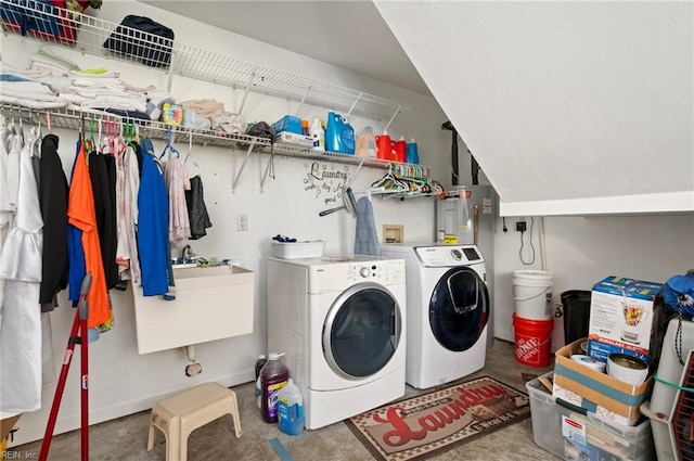 clothes washing area with independent washer and dryer and sink