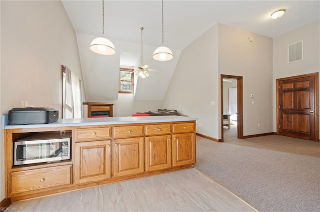 kitchen featuring ceiling fan, light colored carpet, decorative light fixtures, and lofted ceiling