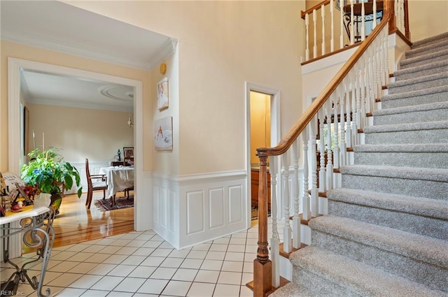 stairs with tile patterned flooring and crown molding