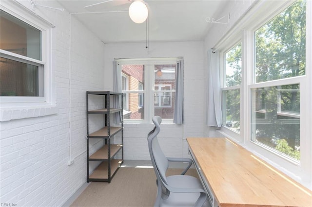 office space with brick wall and a wealth of natural light