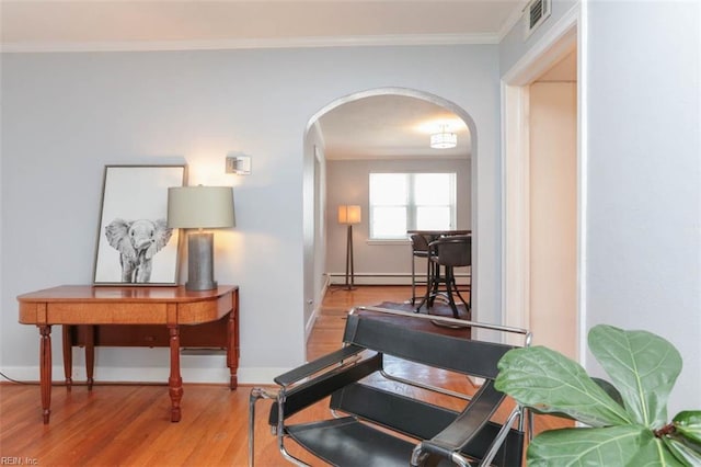 living area with baseboard heating, light hardwood / wood-style flooring, and ornamental molding