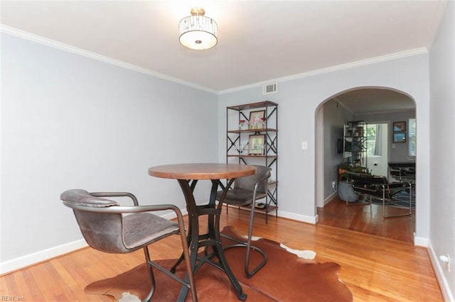 dining area with hardwood / wood-style flooring and crown molding