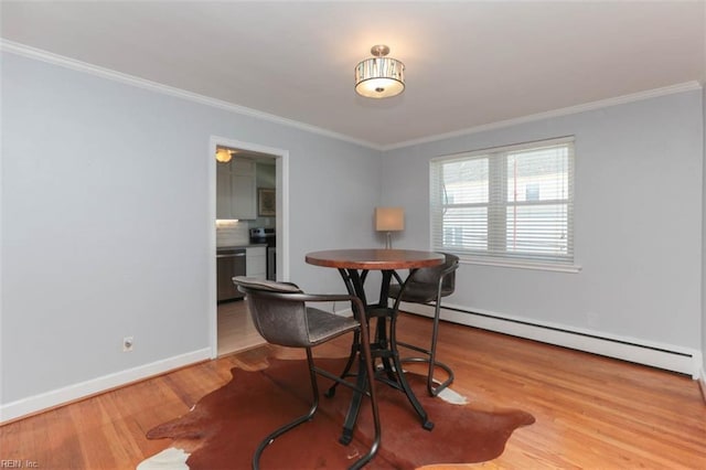 dining room featuring baseboard heating, hardwood / wood-style floors, and ornamental molding