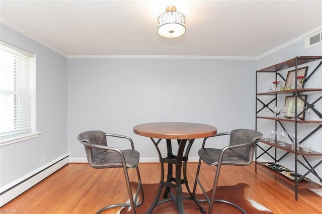 dining room with baseboard heating, crown molding, and wood-type flooring