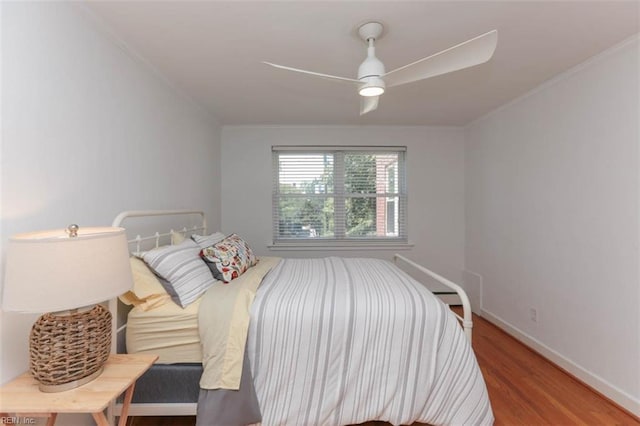 bedroom with wood-type flooring, ceiling fan, and ornamental molding