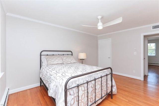 bedroom with hardwood / wood-style floors, crown molding, ceiling fan, and a baseboard heating unit