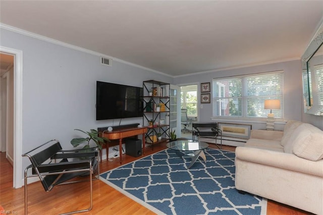 living room featuring a baseboard heating unit, hardwood / wood-style flooring, and ornamental molding