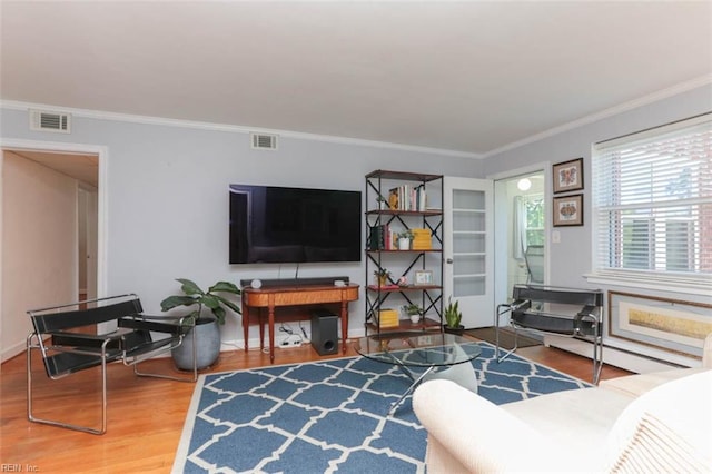 living room with baseboard heating, crown molding, and hardwood / wood-style floors