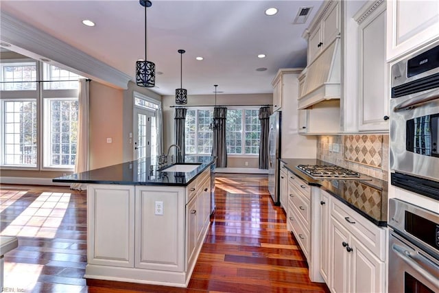 kitchen with sink, pendant lighting, a center island with sink, dark hardwood / wood-style floors, and white cabinetry