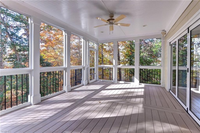 unfurnished sunroom with ceiling fan