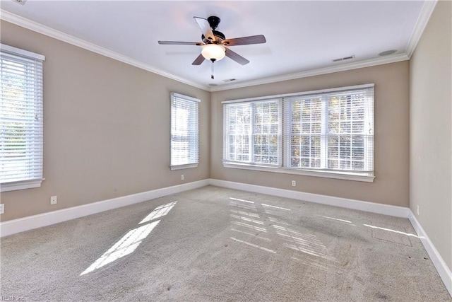 carpeted empty room with a wealth of natural light, ornamental molding, and ceiling fan