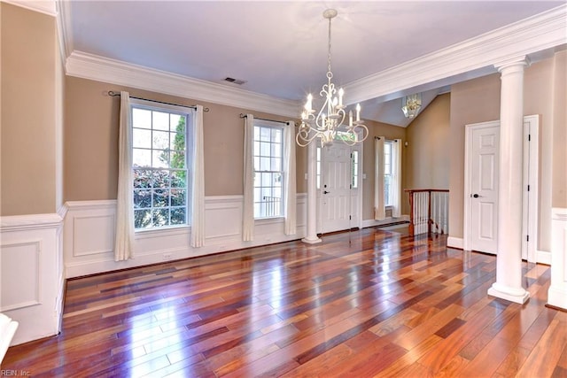 unfurnished dining area with dark hardwood / wood-style floors, decorative columns, ornamental molding, and a notable chandelier