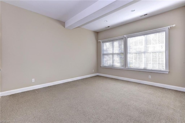 carpeted spare room with beamed ceiling