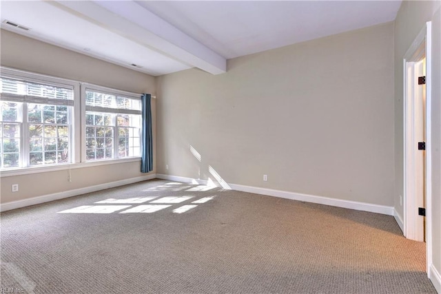 carpeted spare room featuring beamed ceiling