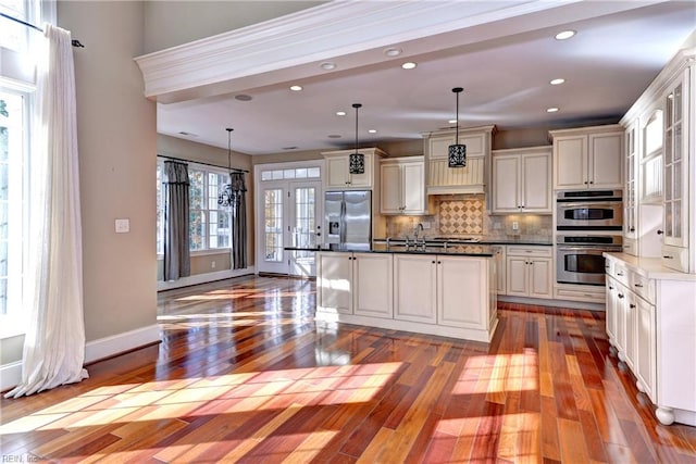 kitchen featuring appliances with stainless steel finishes, plenty of natural light, and hanging light fixtures