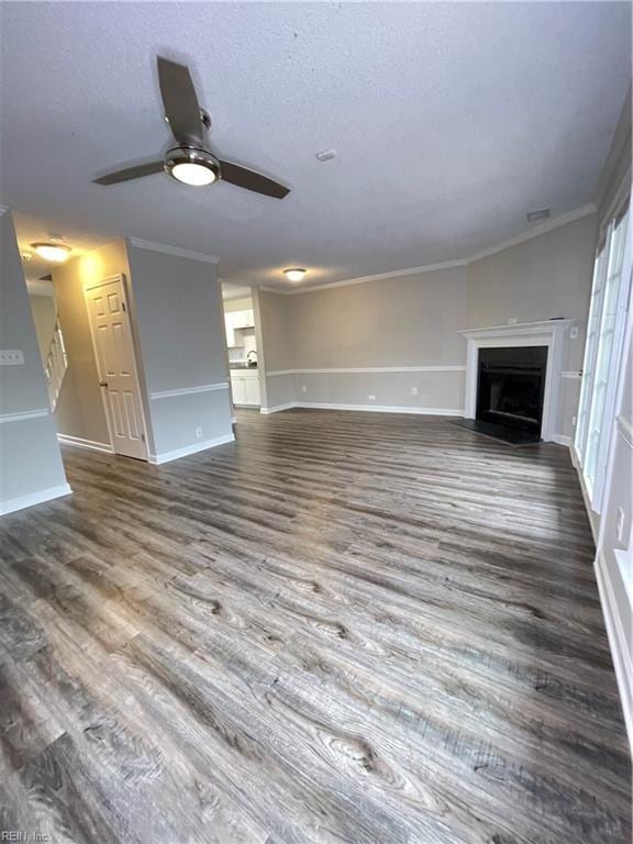 unfurnished living room with wood-type flooring, a textured ceiling, ceiling fan, and ornamental molding