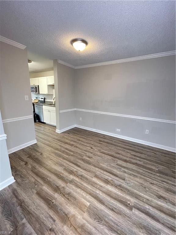 empty room with hardwood / wood-style flooring, ornamental molding, and a textured ceiling