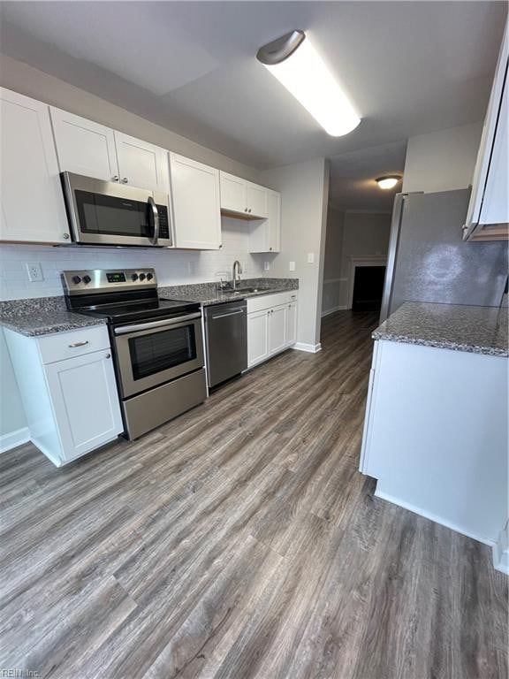 kitchen featuring white cabinets, sink, wood-type flooring, and stainless steel appliances