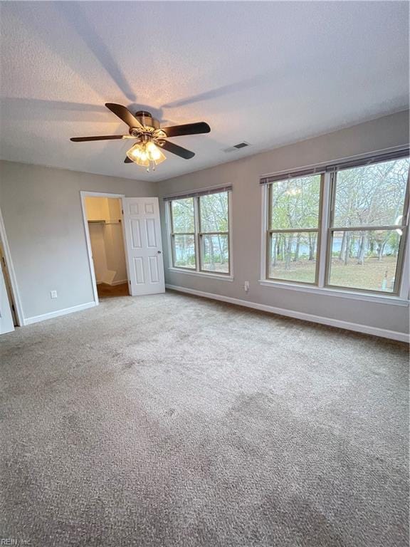 unfurnished bedroom with carpet flooring, ceiling fan, and a textured ceiling