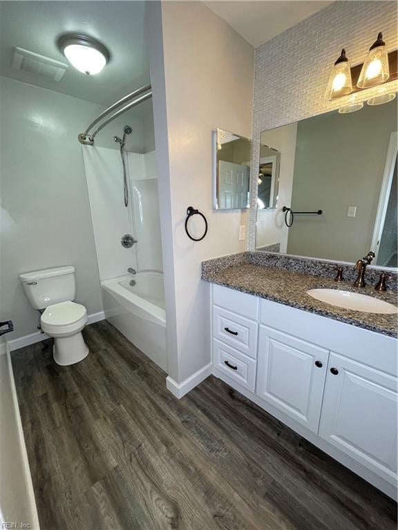 full bathroom with bathtub / shower combination, hardwood / wood-style floors, vanity, and toilet