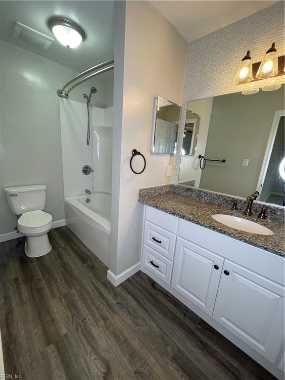 full bathroom with bathing tub / shower combination, toilet, vanity, and hardwood / wood-style flooring