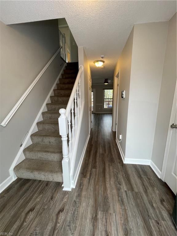 staircase featuring hardwood / wood-style floors and a textured ceiling