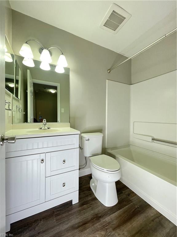 full bathroom featuring shower / washtub combination, toilet, vanity, and hardwood / wood-style flooring