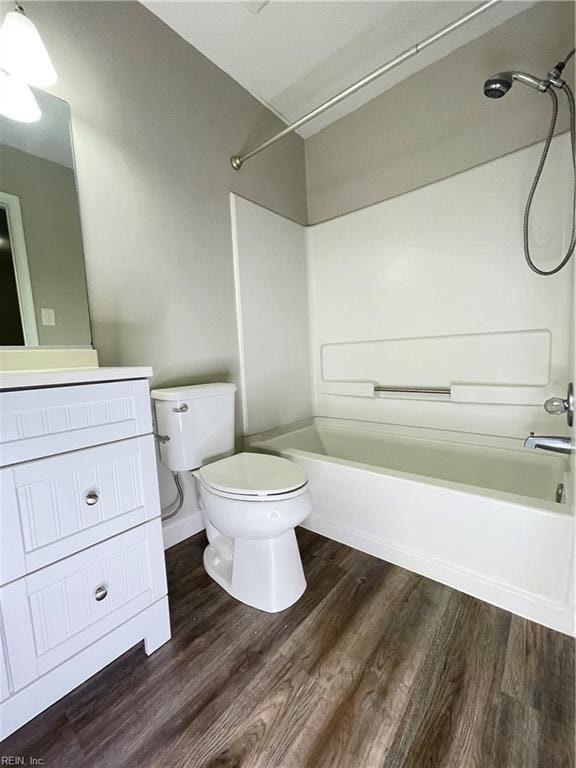 full bathroom featuring hardwood / wood-style floors, vanity, toilet, and shower / bathtub combination