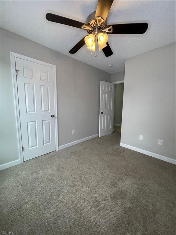 carpeted spare room featuring ceiling fan and a textured ceiling