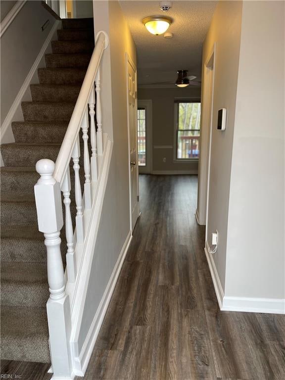 interior space with a textured ceiling, hardwood / wood-style flooring, and ceiling fan