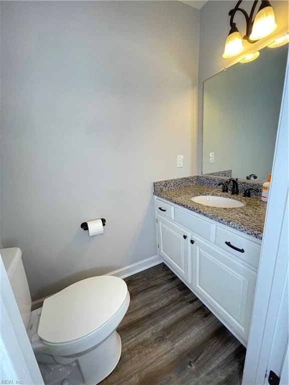 bathroom with hardwood / wood-style flooring, vanity, and toilet