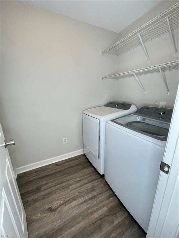 laundry area with washing machine and dryer and dark wood-type flooring