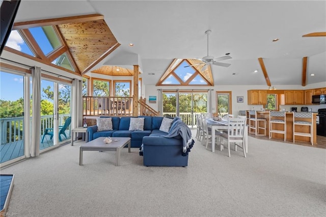 living room featuring light colored carpet, high vaulted ceiling, and ceiling fan