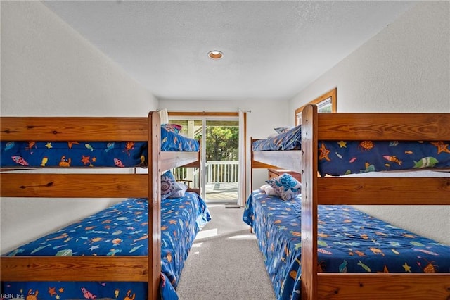 carpeted bedroom with access to exterior and a textured ceiling