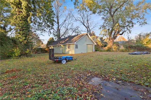 view of yard with a garage and an outbuilding