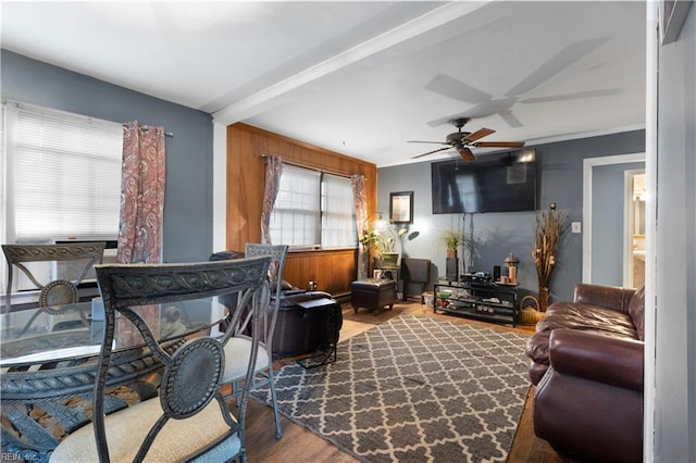 living room featuring ceiling fan, beamed ceiling, and wood-type flooring