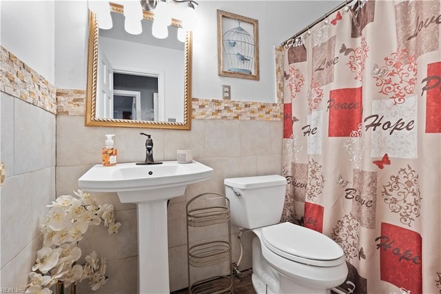 bathroom with a shower with curtain, toilet, and tile walls