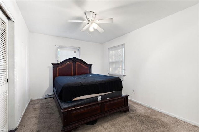 bedroom featuring carpet, a closet, ceiling fan, and a baseboard heating unit