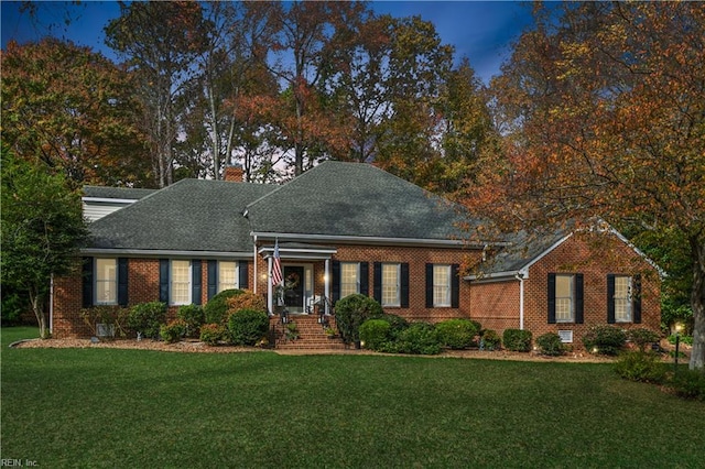 cape cod house featuring a lawn