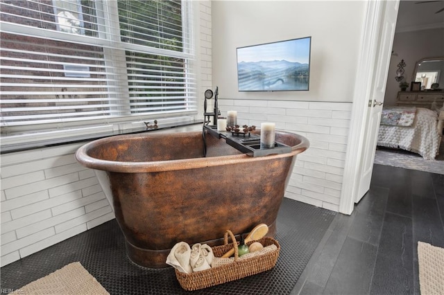 bathroom featuring crown molding, a bathtub, and hardwood / wood-style flooring