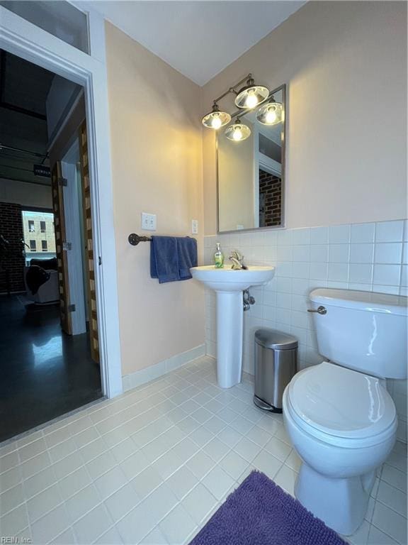 bathroom with tile patterned flooring, tile walls, and toilet