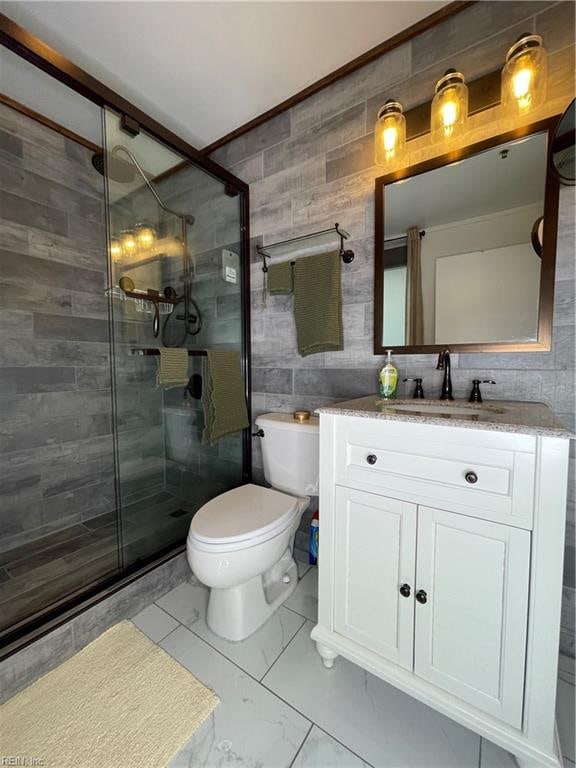 bathroom featuring vanity, a shower with door, decorative backsplash, toilet, and tile walls