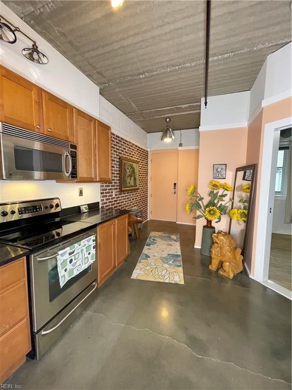 kitchen featuring stainless steel appliances and brick wall