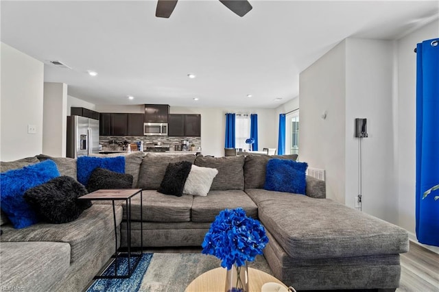 living room with light hardwood / wood-style floors and ceiling fan