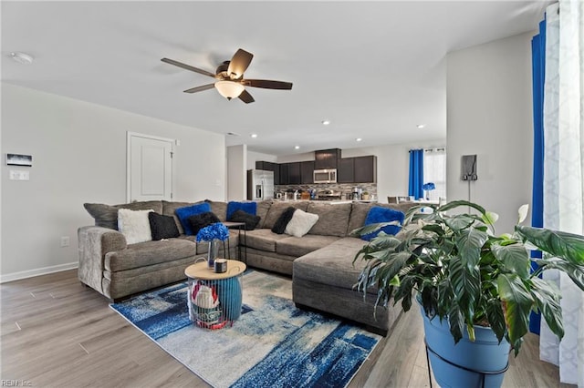 living room with light hardwood / wood-style flooring and ceiling fan