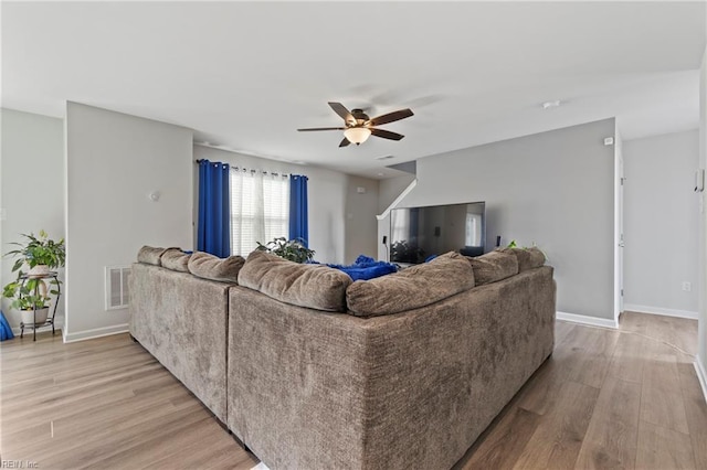 living room featuring ceiling fan and light wood-type flooring