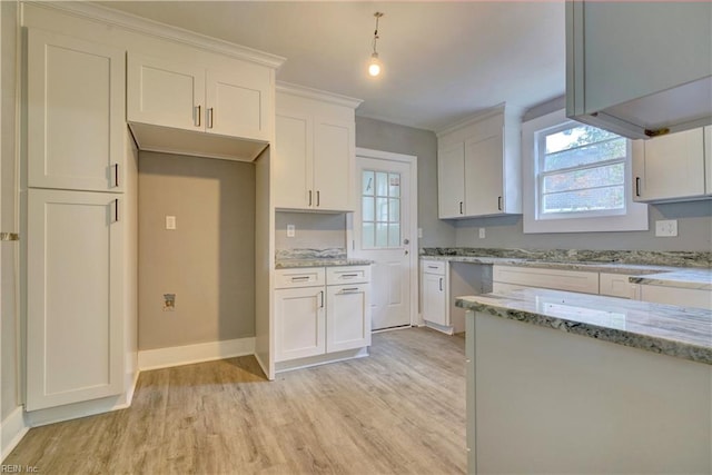 kitchen featuring white cabinetry, hanging light fixtures, light stone counters, and light wood-type flooring