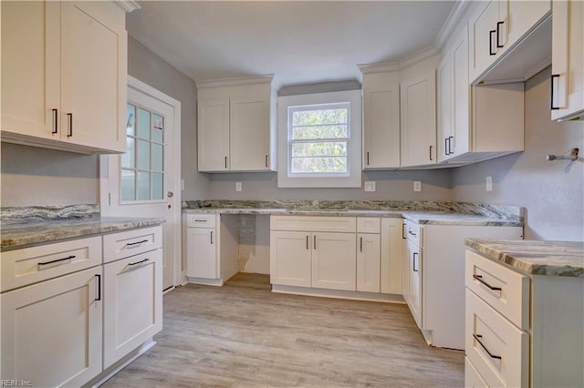 kitchen featuring white cabinets, light stone counters, and light hardwood / wood-style flooring