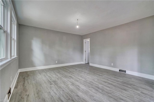 unfurnished room with hardwood / wood-style flooring