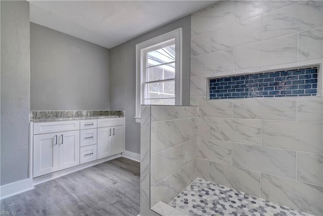 bathroom with vanity, wood-type flooring, and tiled shower